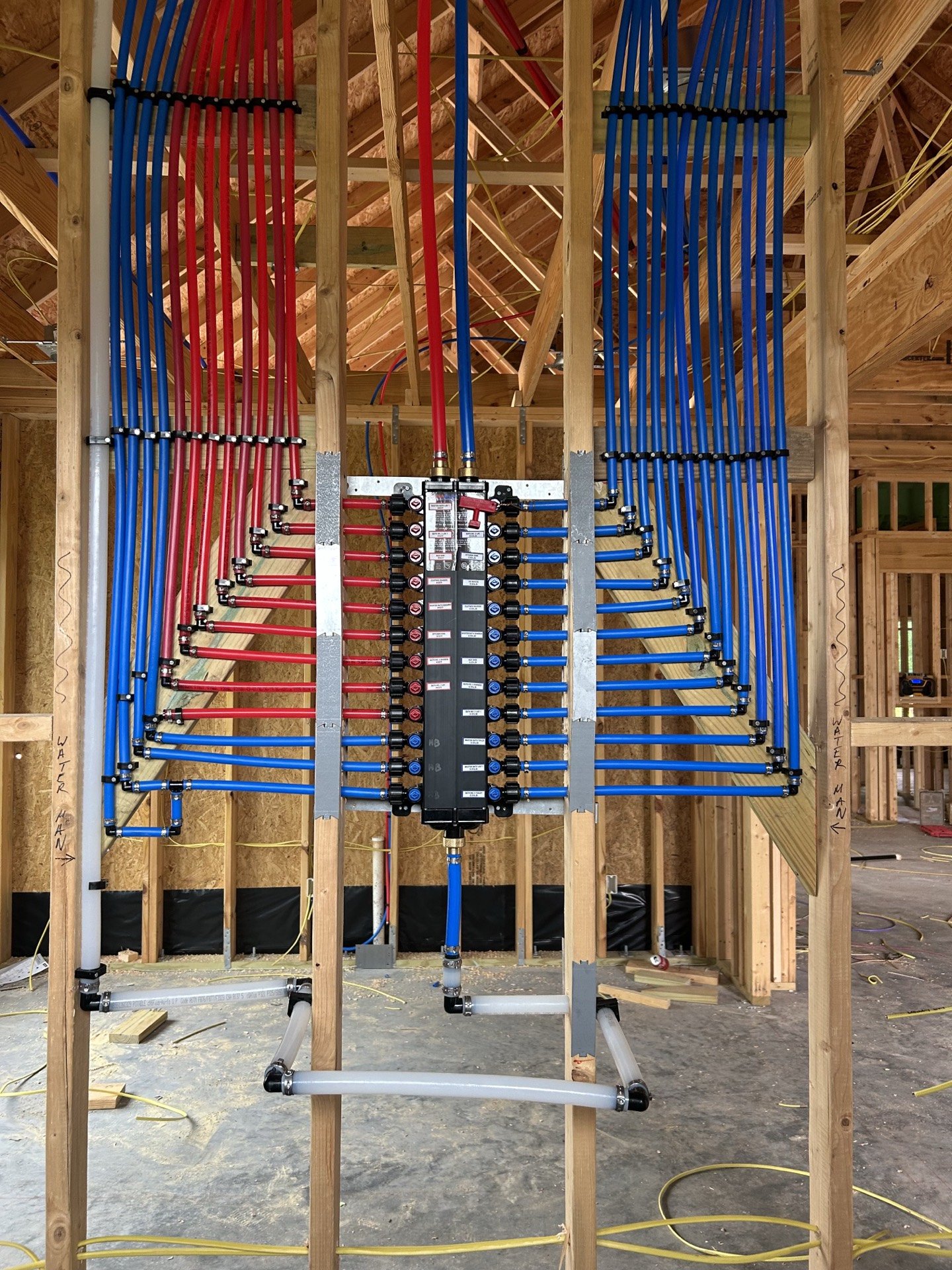 PEX water distribution manifold installed in new construction framing